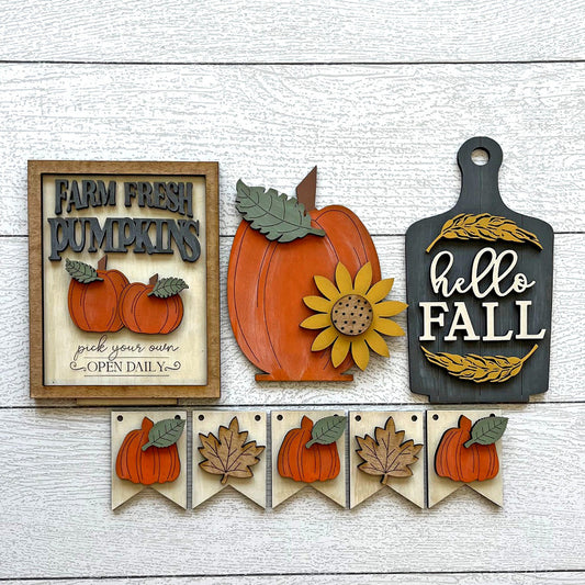 Set of autumn-themed decorative signs on a wooden surface