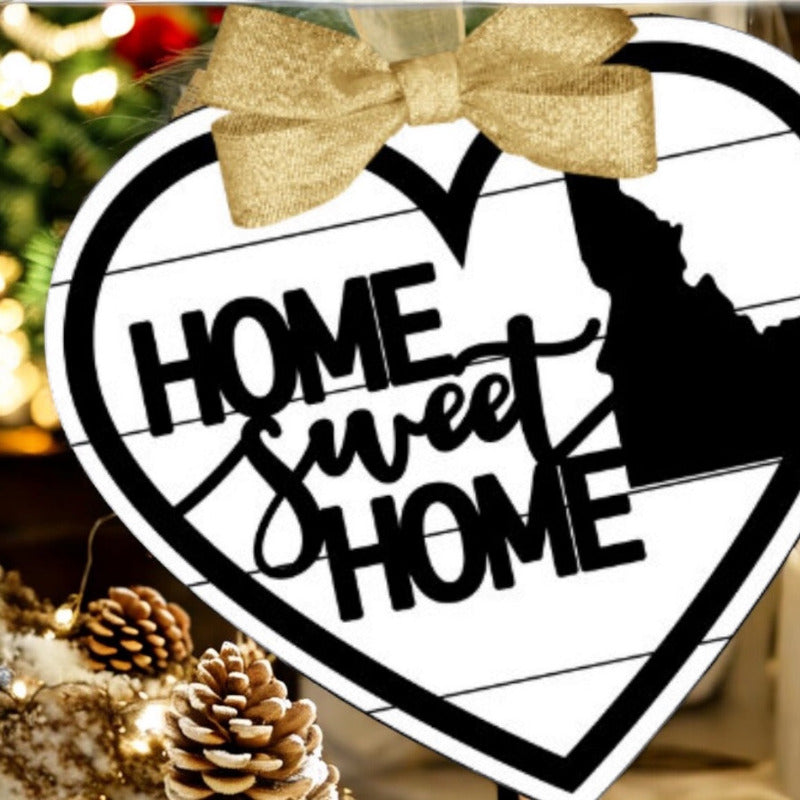 Decorative ornament with 'Home Sweet Home' text and a gold bow, surrounded by festive decorations.
