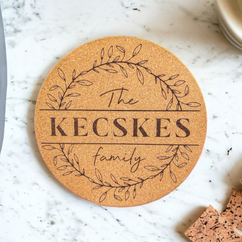 Round cork coaster with 'The Kecskes family' text on a marble surface