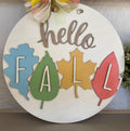 Decorative sign with 'hello Fall' text and colorful leaf-shaped letters on a white background.