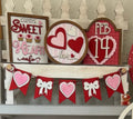 Valentine's Day themed decorations including signs and a banner on a shelf.